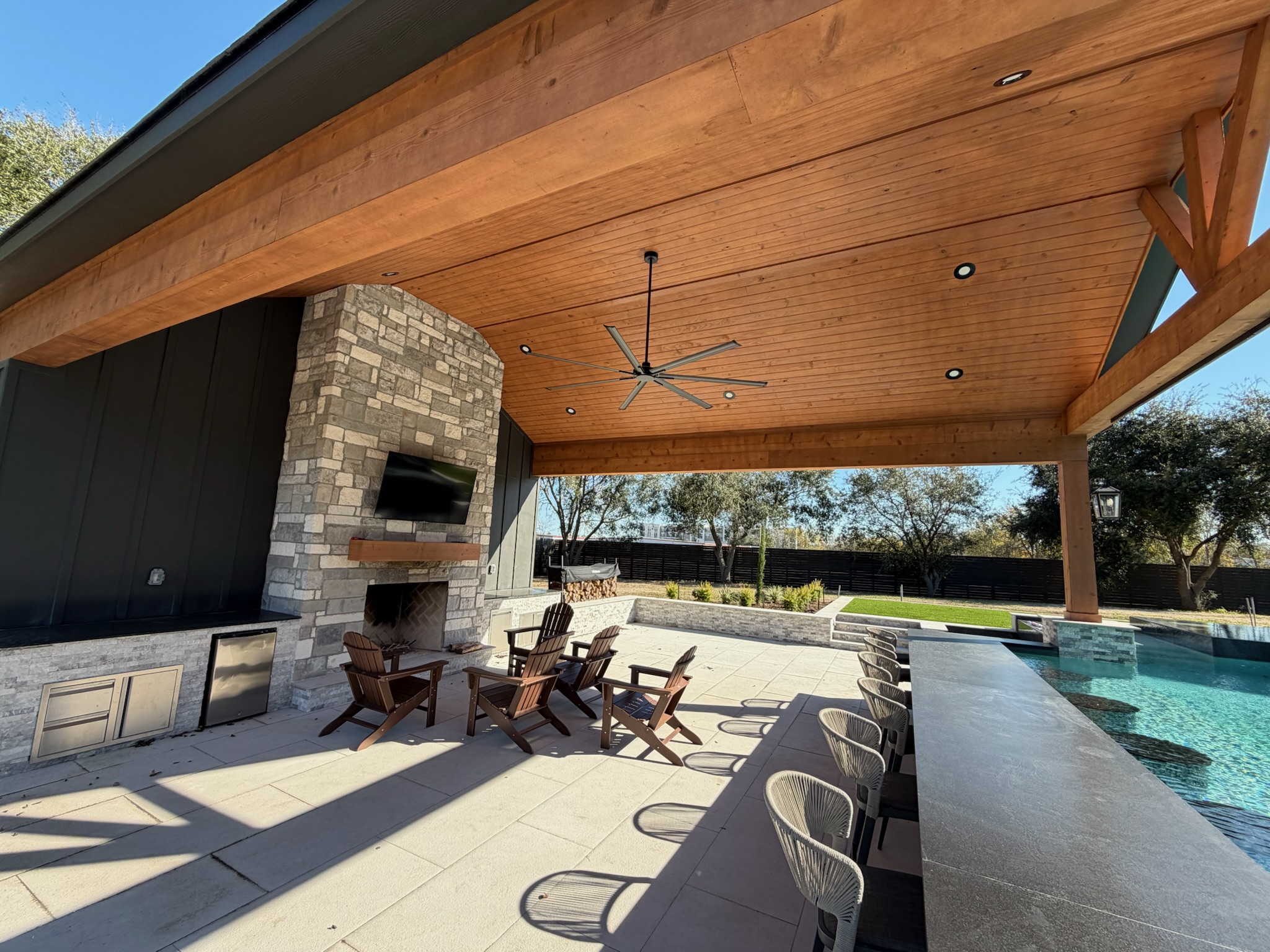 Outdoor patio with pool, fireplace, wooden ceiling, and modern seating area
